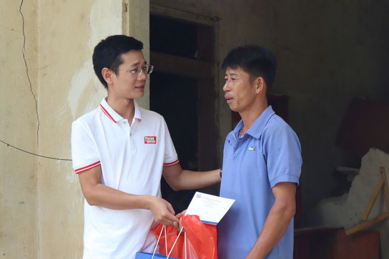 Nhà báo Tiến Nguyên (Tạp chí Pháp luật và Phát triển) trao nhu yếu phẩm cho bà con ảnh hưởng lũ lụt tại huyện Bảo Yên, Lào Cai.