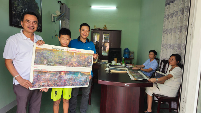 Học sinh THCS Quảng Trị được bố dẫn đến Văn phòng thường trú Báo Nhân Dân tại Quảng Trị nhận phụ trang số báo đặc biệt.