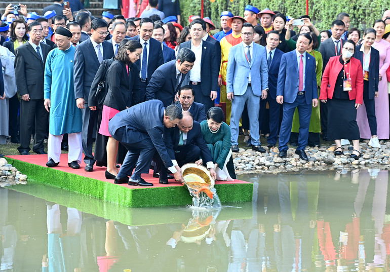 Chủ tịch nước Nguyễn Xuân Phúc và Phu nhân cùng các đại biểu kiều bào thả cá chép tiễn ông Công, ông Táo theo phong tục truyền thống tại hồ Sen trong Khu di tích Hoàng Thành Thăng Long.