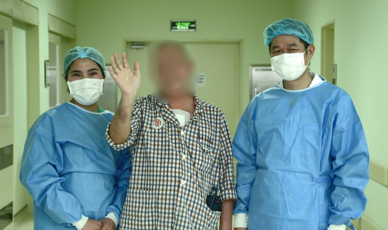 Các nhân viên y tế chúc mừng bệnh nhân xuất viện.