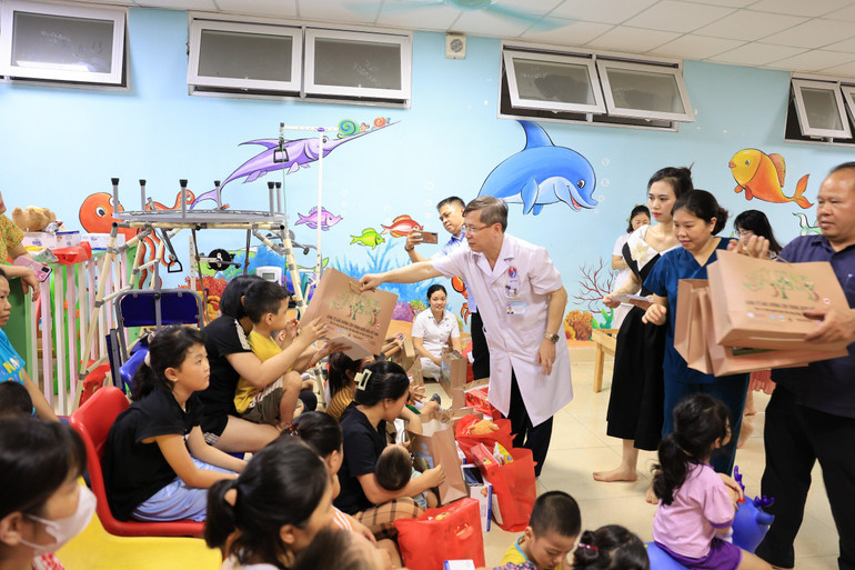 Thầy thuốc Nhân dân, Phó Giáo sư, Tiến sĩ Vũ Nam, Bí thư Đảng ủy, Giám đốc bệnh viện trao quà cho các bệnh nhi.
