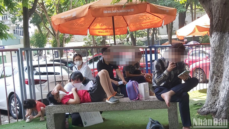 Người lớn, trẻ nhỏ vật vã giữa trời nắng nóng chờ đợi.