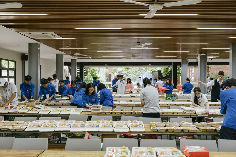 Các tình nguyện viên chuẩn bị bữa ăn nhẹ cho các em học sinh tham gia kỳ khảo sát đánh giá năng lực.