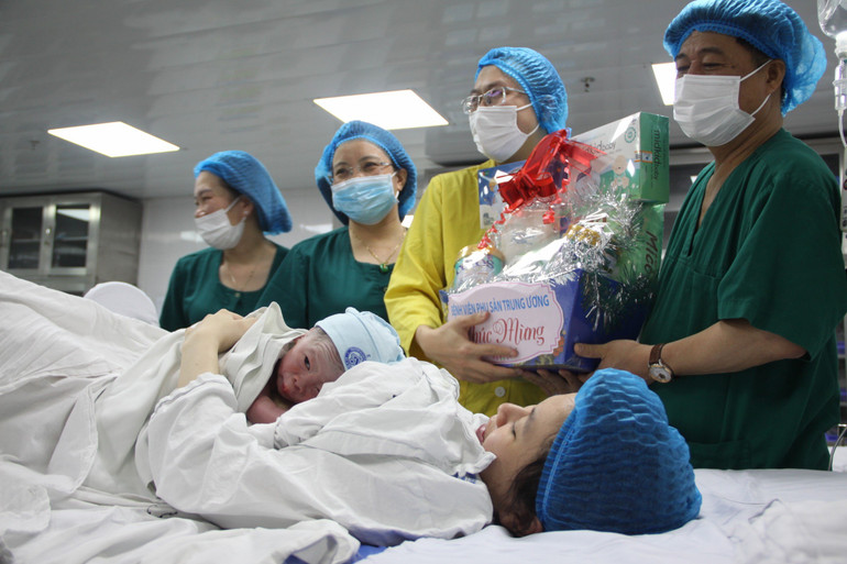 Ông Đinh Anh Tuấn, Vụ trưởng Vụ Sức khỏe Bà mẹ-Trẻ em (Bộ Y tế), kiêm nhiệm phụ trách, quản lý, điều hành Bệnh viện Phụ sản Trung ương cùng kíp trực chúc mừng gia đình bé đầu tiên được sinh ra trong năm 2024.