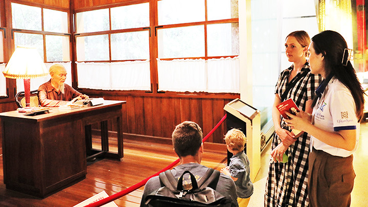 Du khách nước ngoài nghe kể chuyện về Bác khi thăm Bảo tàng Hồ Chí Minh.