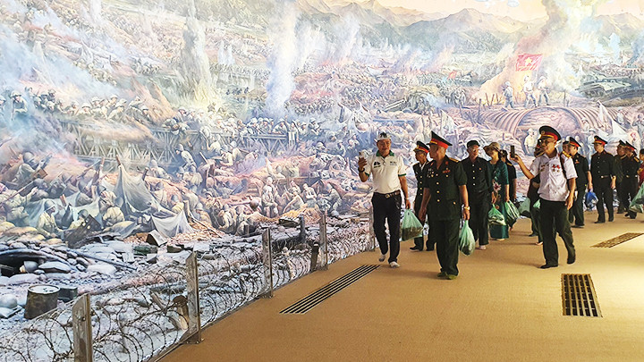 Các cựu chiến binh và du khách tham quan bức tranh toàn cảnh chiến dịch Điện Biên Phủ tại bảo tàng.
