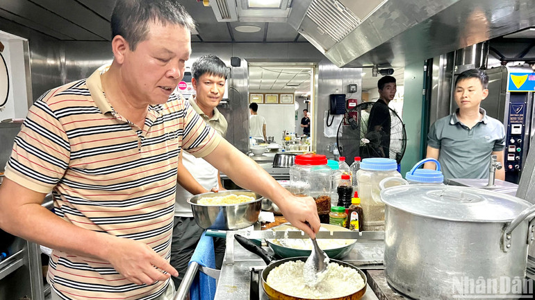 Chuẩn Đô đốc Phạm Như Xuân (bên trái), Phó Tư lệnh Quân chủng Hải quân tự tay chuẩn bị bữa ăn cho cán bộ, chiến sĩ, đại biểu trên tàu KN290.