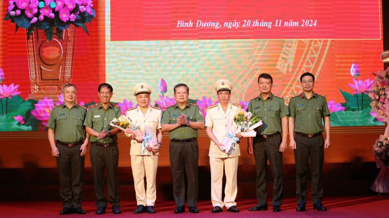 Đại diện lãnh đạo Cục Quản lý Xuất nhập cảnh, Bộ Công an trao tặng hoa chúc mừng Thượng tá Bùi Thanh Trực và Thượng tá Phan Huy Văn.