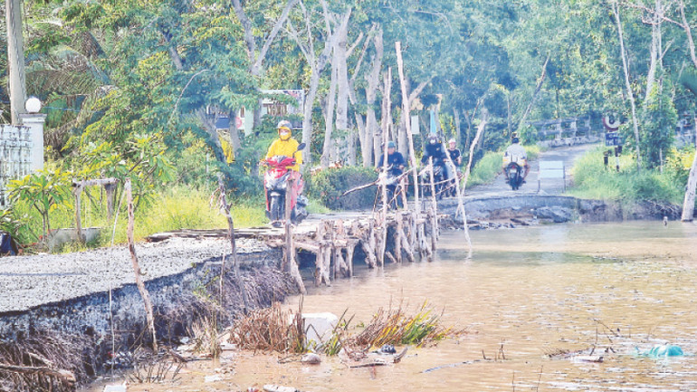 Tuyến đường về xã Tân Dân, huyện Đầm Dơi, người dân di chuyển bằng xe máy khó khăn do đường bị chia cắt vì sạt lở đất. Tuyến đường về xã Tân Dân, huyện Đầm Dơi, người dân di chuyển bằng xe máy khó khăn do đường bị chia cắt vì sạt lở đất.