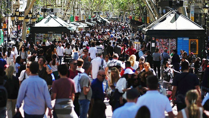 Du khách đi bộ dọc một con phố ở Barcelona. Ảnh: AFP