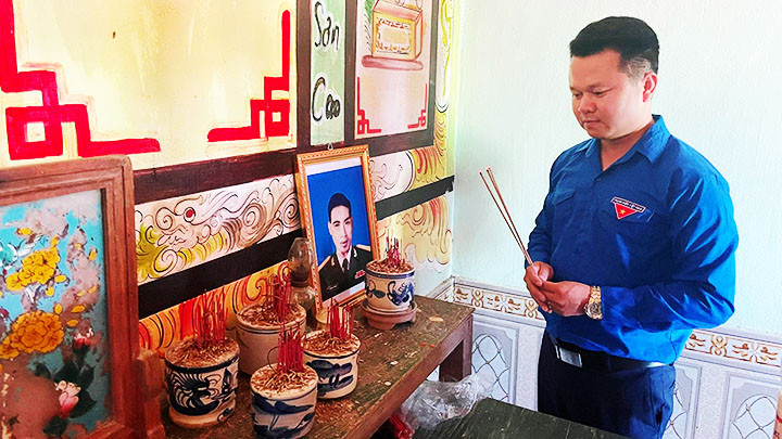 Thắp nén nhang đến anh hùng liệt sĩ sau khi trao tặng tấm ảnh được phục dựng.