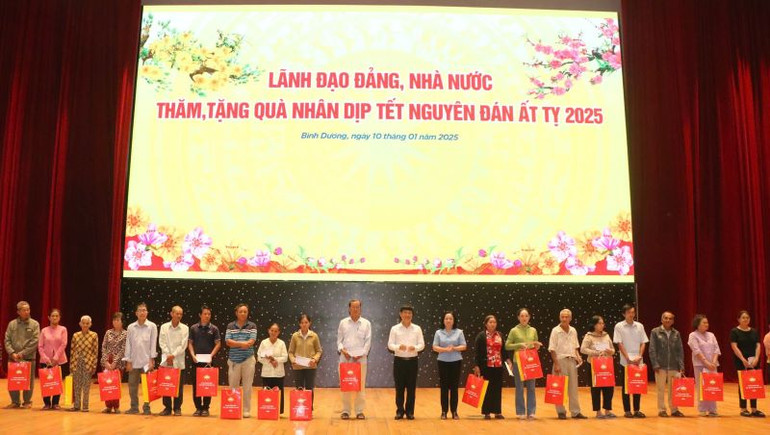 Lãnh đạo Ủy ban nhân dân tỉnh Bình Dương và đại diện các bộ, ngành trao tặng quà cho các hộ gia đình sách sách, hộ nghèo.