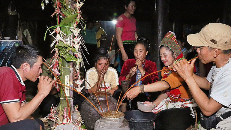 Người dân tham gia lễ “Mượng ma” cùng nhau vít rượu cần.