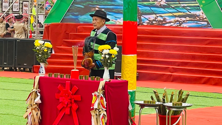 Già làng Giàng A Su, tay ôm gà trống là chủ lễ cúng trong lễ hội. (Ảnh: THANH SƠN)