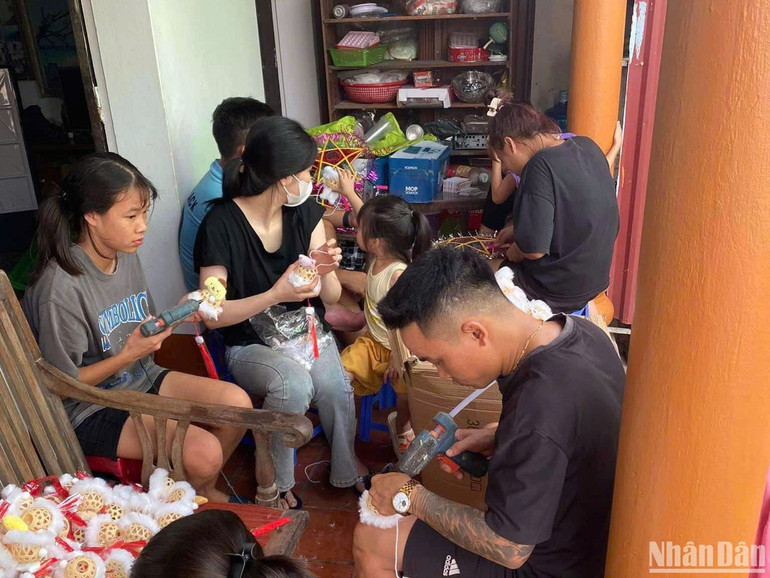 Đoàn viên thanh niên thôn Chi đoàn 10 chuẩn bị những chiếc đèn Trung thu trước khi... đem lên thuyền.