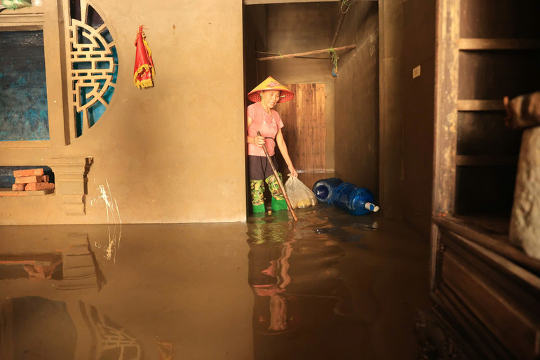 Tại khu vực bếp phía sau nhà bà Tấp, nước vẫn ngập tới bụng chân.