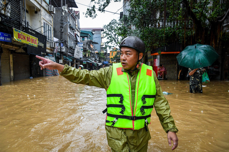 Gọi dân sơ tán giữa dòng nước lụt tại phố Bảo Linh chiều 11/9.