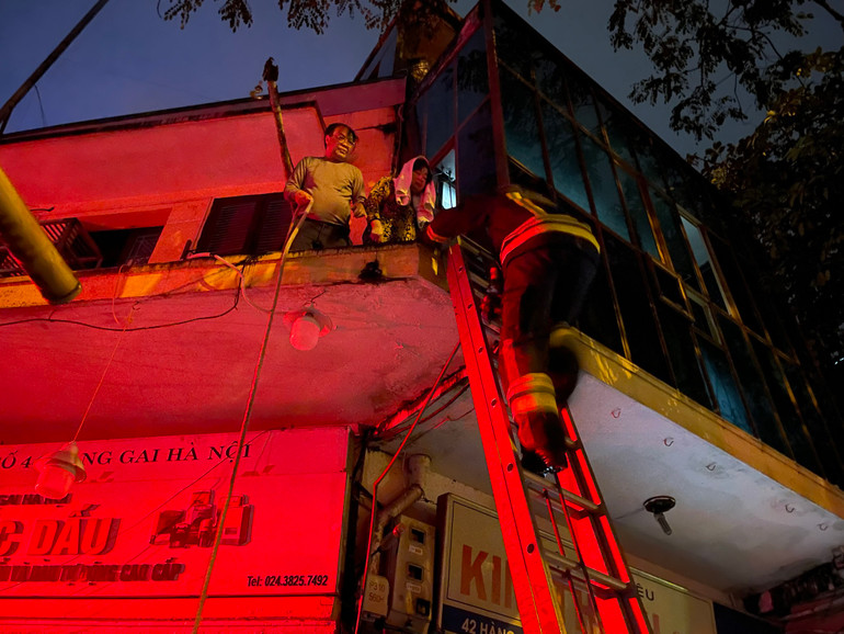 Do có 2 cụ già mắc kẹt trên tầng 2, cảnh sát đã phải bắc thang chuyên dụng để tiếp cận.