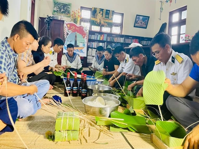 Quân và dân quây quần cùng nhau gói bánh chưng đón Tết.