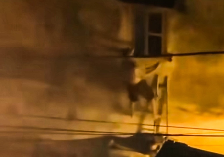 Hình ảnh nam thanh niên dùng búa cố gắng đập thủng bức tường để cứu 3 nạn nhân ra ngoài. (Ảnh cắt từ clip)