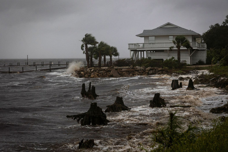 Sóng đánh vào kè chắn sóng của một ngôi nhà vào thứ năm tại Eastpoint, Florida. (Ảnh: Reuters)
