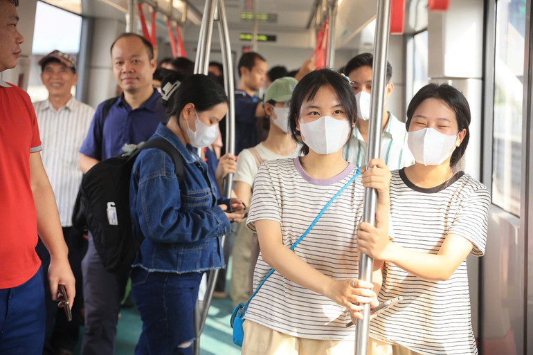 Phía bên trong tàu điện chật kín người. Nhiều hành khách phải đứng. Tuy vậy, tất cả đều tỏ ra vô cùng hào hứng.