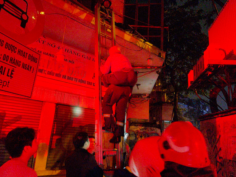 Các chiến sĩ cõng một cụ già xuống đất an toàn.