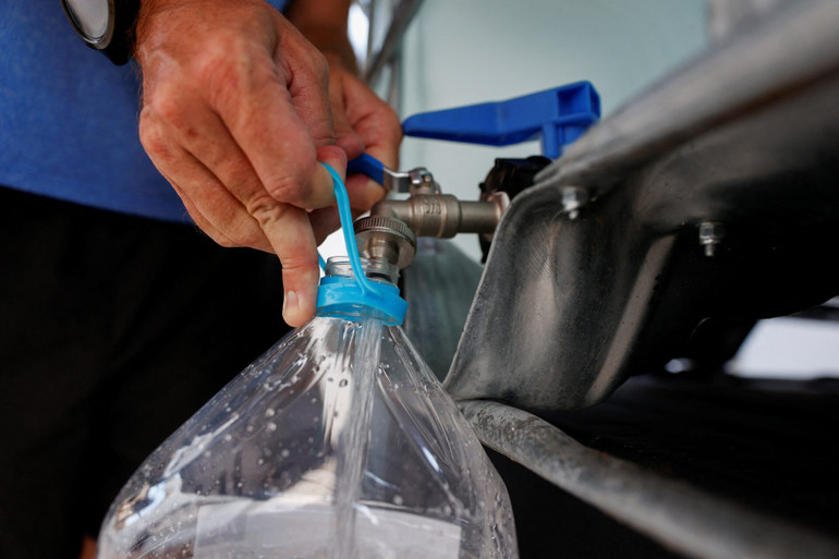 Một người dân lấy nước từ một bể chứa vì nước máy không thể uống được do hạn hán ở Teulada, Alicante, Tây Ban Nha (Ảnh: Reuters)