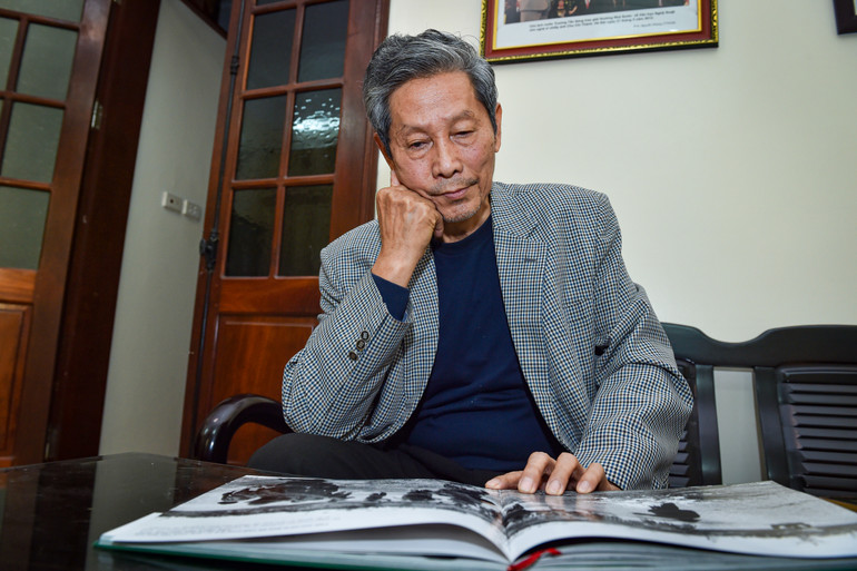 Nghệ sĩ nhiếp ảnh Chu Chí Thành trầm tư bên cuốn sách ảnh Ký ức chiến tranh của mình. Nghệ sĩ nhiếp ảnh Chu Chí Thành trầm tư bên cuốn sách ảnh Ký ức chiến tranh của mình.