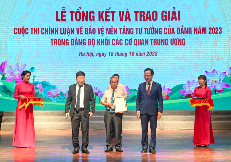 Phó Bí thư Thường trực Đảng ủy Khối các cơ quan Trung ương Lại Xuân Lâm và Phó Tổng Biên tập Báo Nhân Dân Quế Đình Nguyên trao thưởng cho tác giả có “Tác phẩm có tính lý luận, nghiên cứu chuyên sâu”. (Ảnh: DUY LINH)