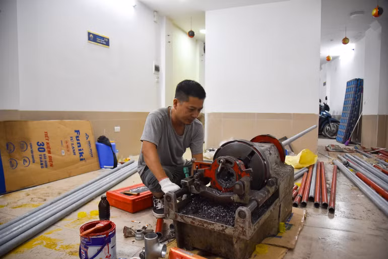 Công nhân tiến hành lắp đặt hệ thống chữa cháy tự động tại các tầng. (Ảnh: Nhật Quang)