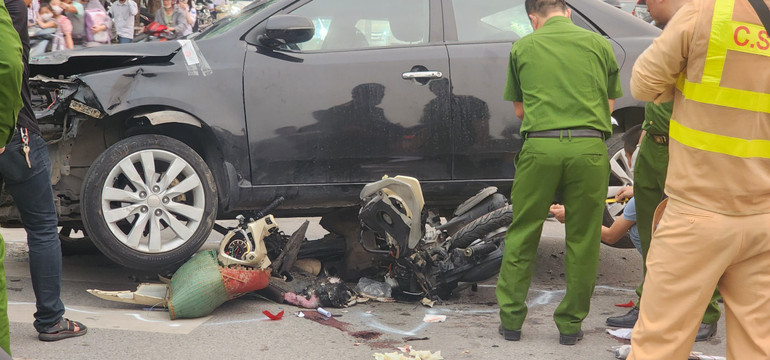 Phía dưới gầm xe vẫn còn một chiếc xe máy bị mắc kẹt.