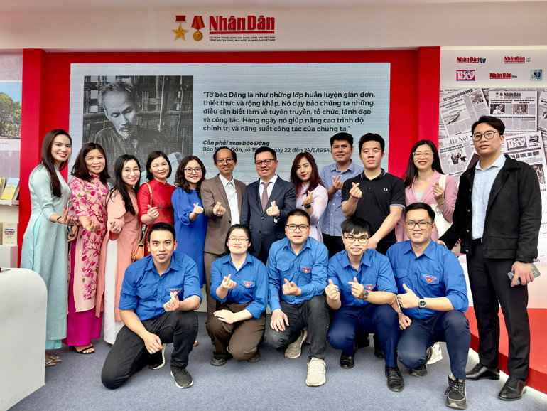 Đồng chí Lê Quốc Minh, Ủy viên Trung ương Đảng, Tổng Biên tập Báo Nhân Dân, Phó Trưởng Ban Tuyên giáo Trung ương, Chủ tịch Hội Nhà báo Việt Nam chụp ảnh lưu niệm cùng các đoàn viên, thanh niên Báo Nhân Dân.