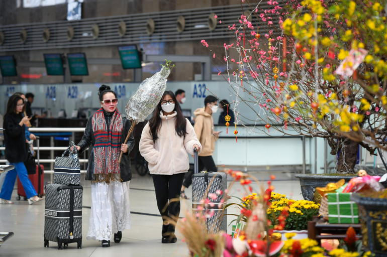 Ngoài hành lý bình thường, nhiều hành khách còn mang theo cành đào Nhật Tân về làm quà cho người thân và bạn bè. (Ảnh: Thành Đạt)