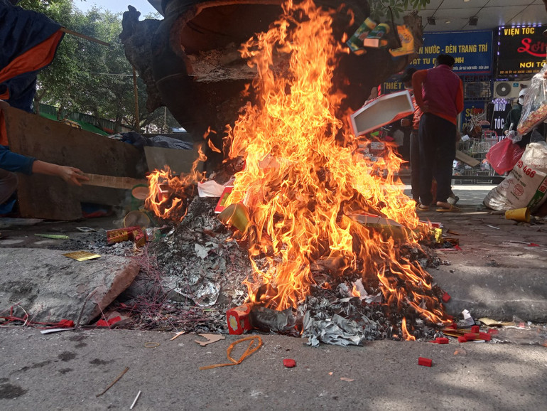 Lửa trên vỉa hè, tro bụi đã tràn xuống lòng đường. Lửa trên vỉa hè, tro bụi đã tràn xuống lòng đường.