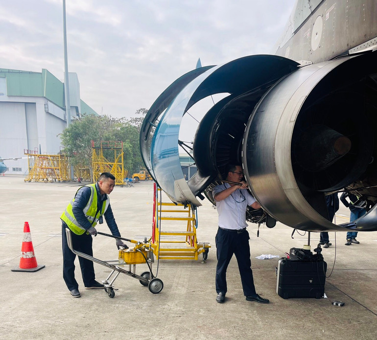 Kỹ sư Nguyễn Như Nam (áo trắng) thực hiện nhiệm vụ bảo dưỡng động cơ máy bay.