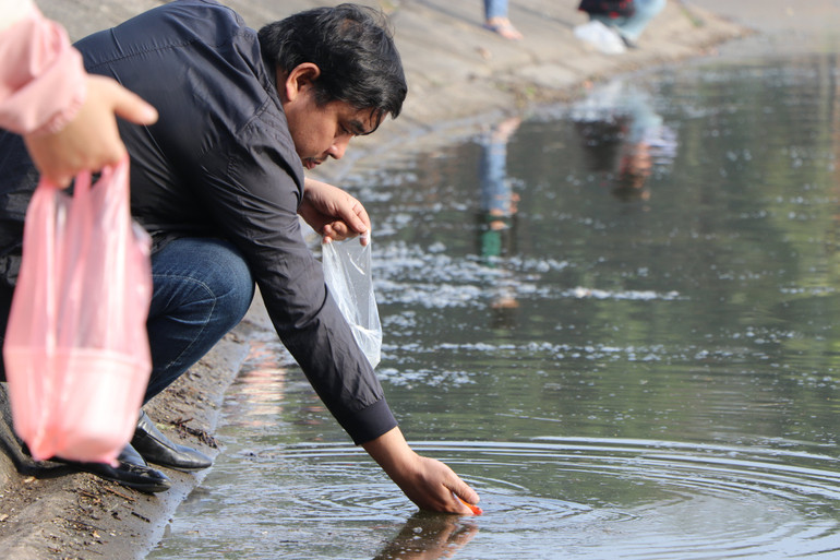 Mặt nước hồ Linh Đàm đen đặc bởi tro tiền vàng. Mặt nước hồ Linh Đàm đen đặc bởi tro tiền vàng.