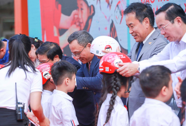 Đại diện Ban tổ chức trao tặng mũ bảo hiểm đạt chuẩn cho các em học sinh Trường Phú Đô.