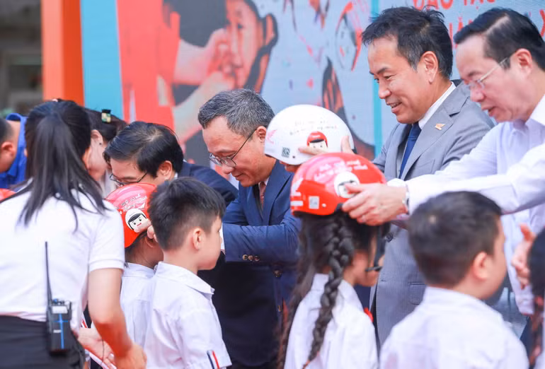 Đại diện Ban tổ chức trao tặng mũ bảo hiểm đạt chuẩn cho các em học sinh Trường Phú Đô.