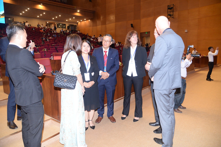 Các đại biểu trong nước và nước ngoài trao đổi tại hội nghị.