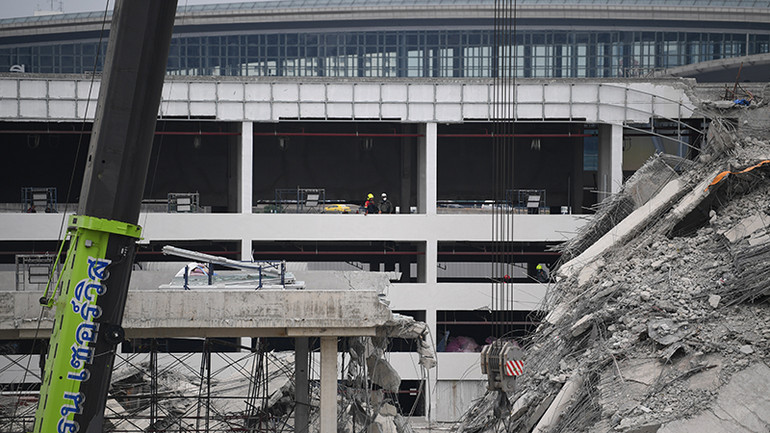 Các lực lượng cứu hộ đã vào các tòa nhà kế bên đống đổ nát để tìm hướng tiếp cận từ phía sau. (Ảnh: XUÂN SƠN)