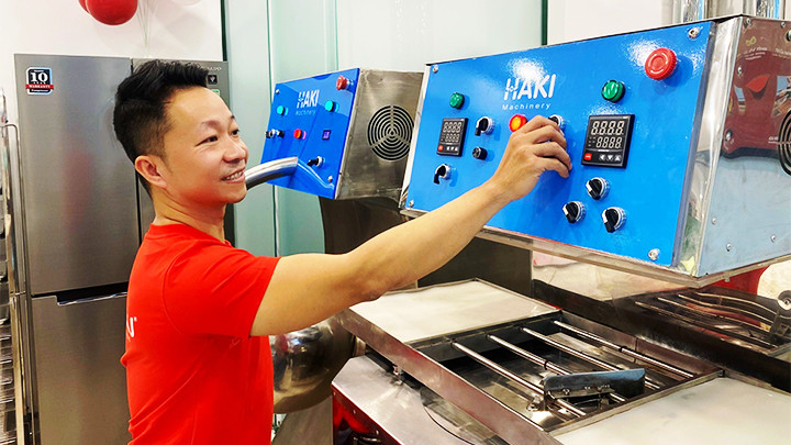 Nguyễn Hồng Huy bên những chiếc máy làm sô-cô-la do anh chế tạo.