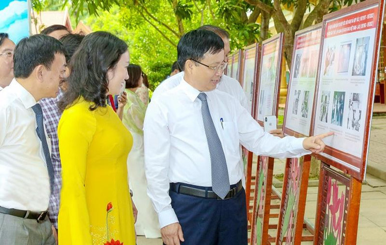 Các đại biểu xem hình ảnh, tư liệu trưng bày tại triển lãm. (Ảnh: Đình Tuyên)