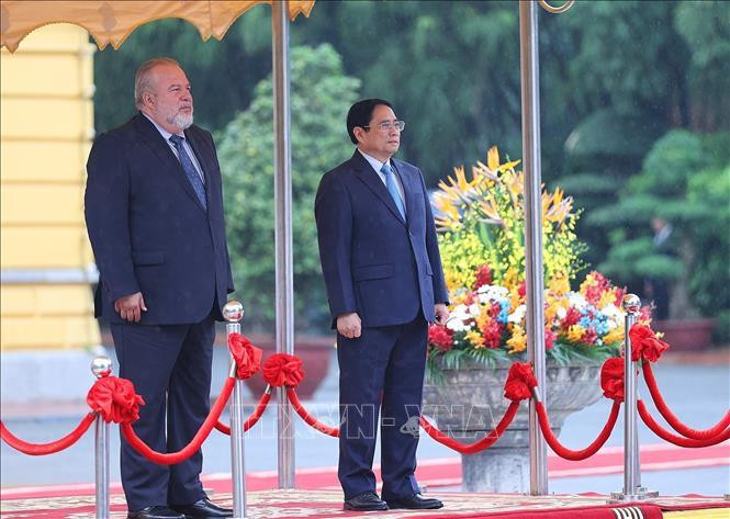 Thủ tướng Phạm Minh Chính và Thủ tướng nước Cộng hòa Cuba Manuel Marrero Cruz nghe quân nhạc cử Quốc thiều hai nước. (Ảnh: Dương Giang-TTXVN)