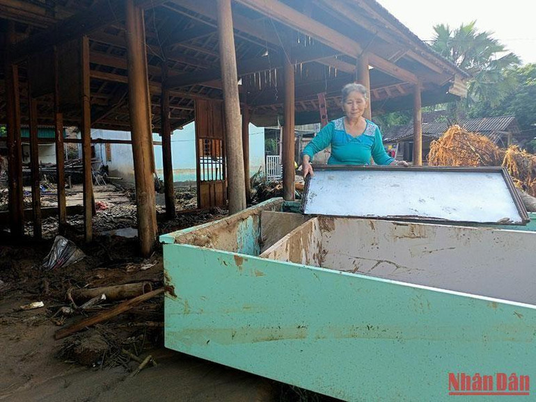 Bà Ngân Thị Tâm (71 tuổi), bản Hòa Sơn, xã Tà Cạ, nhà bị lũ trôi hết, chỉ kịp chạy thoát thân, đang lần tìm tài sản trong bùn cát. Hai nhà con bên cạnh cũng rơi vào hoàn cảnh tương tự.