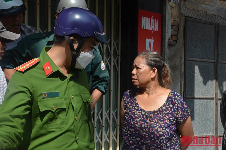 Bà Bùi Thị Thu Hồng, chủ căn nhà bị cháy chưa hết hoảng loạn đang tường trình lại sự việc với lực lượng chức năng.