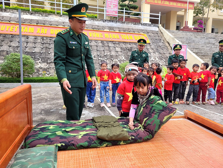 Hướng dẫn các cháu cách gấp chăn màn.