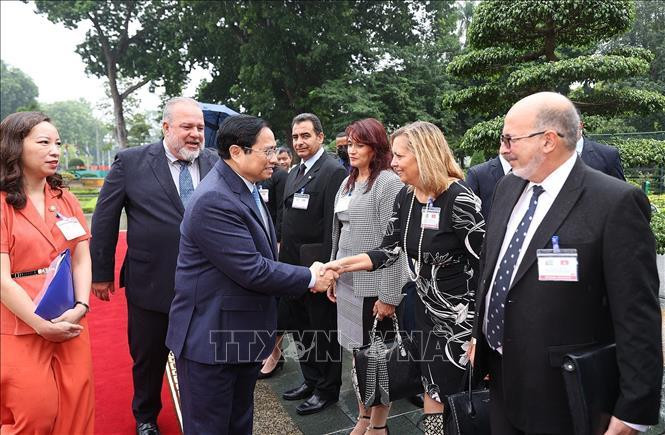 Thủ tướng nước Cộng hòa Cuba Manuel Marrero Cruz giới thiệu với Thủ tướng Phạm Minh Chính thành viên Đoàn Cuba. (Ảnh: Dương Giang-TTXVN)