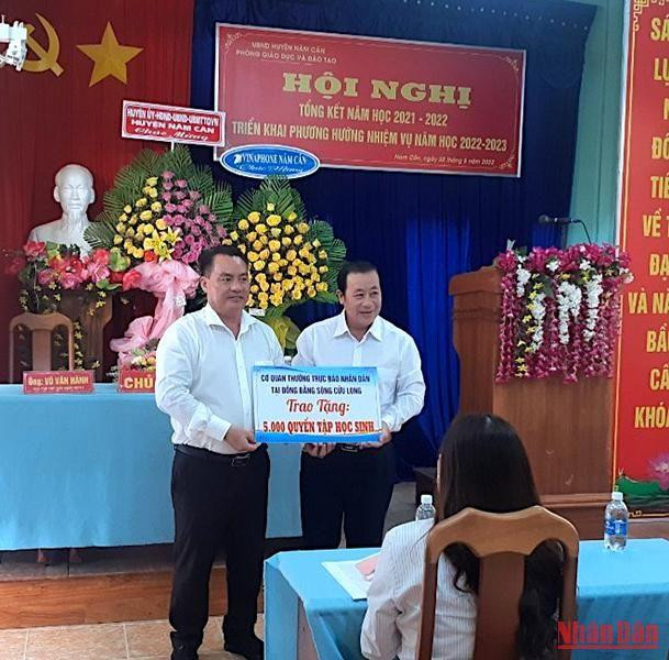 Phó Chủ tịch Ủy ban nhân dân huyện Năm Căn (bìa trái) tiếp nhận tập hỗ trợ từ Báo Nhân Dân vào chiều 31/8.