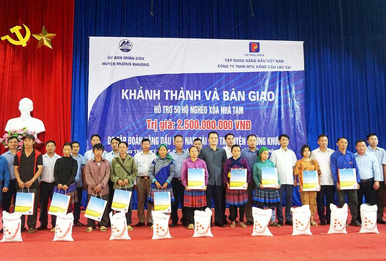 Lãnh đạo Tập đoàn Xăng dầu và lãnh đạo huyện Mường Khương trao quà cho các hộ nghèo.